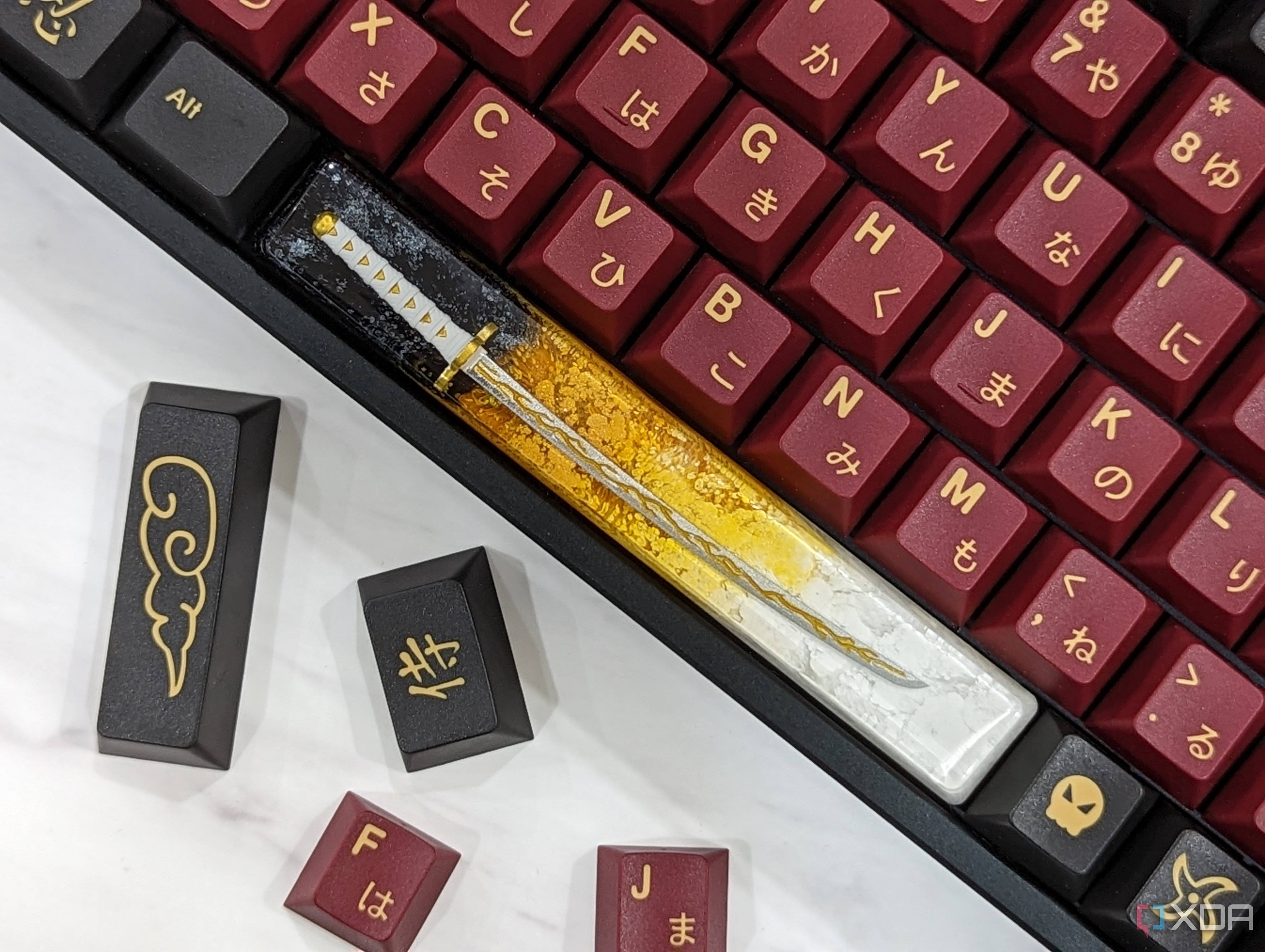 An image of a mechanical keyboard with GMK Red Samurai keycaps kept on a white marble.