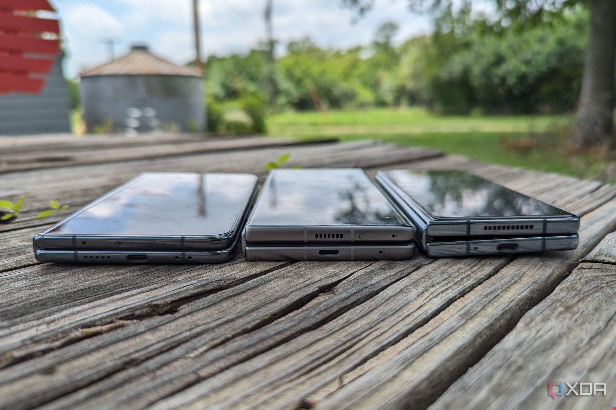 Google Pixel Fold, Tecno Phantom V Fold, and Samsung Galaxy Z Fold 4 lying flat on a table.