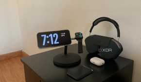iPhone showing the time next to a smartwatch and headphones