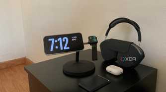 iPhone showing the time next to a smartwatch and headphones