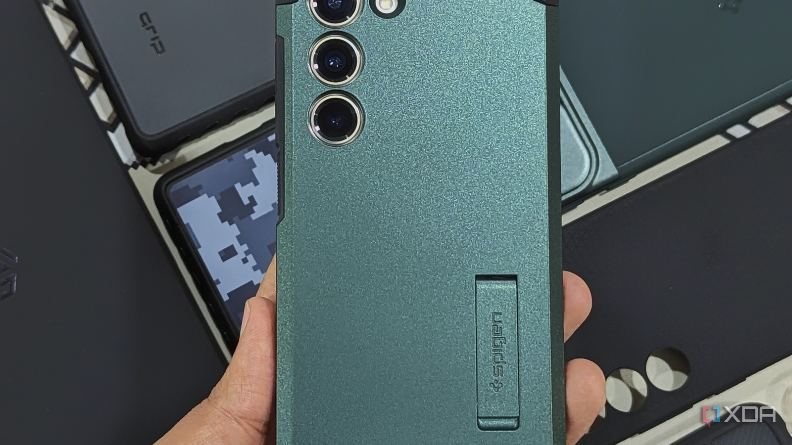 An image showing a person holding Samsung's Galaxy S23 with Spigen Tough Armor case installed on it.