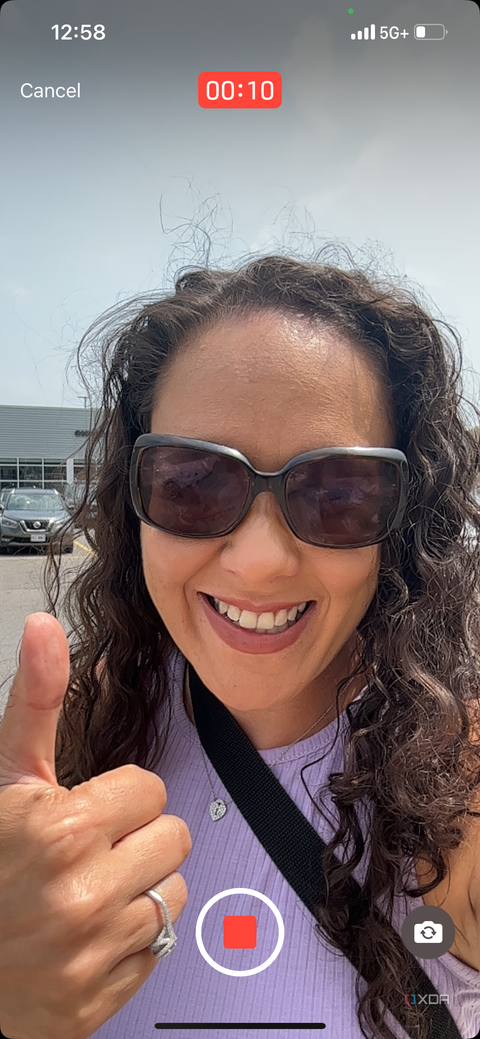 A woman wearing sunglasses giving thumbs up with a record button at the bottom of the screen and 10 seconds showing at the top.