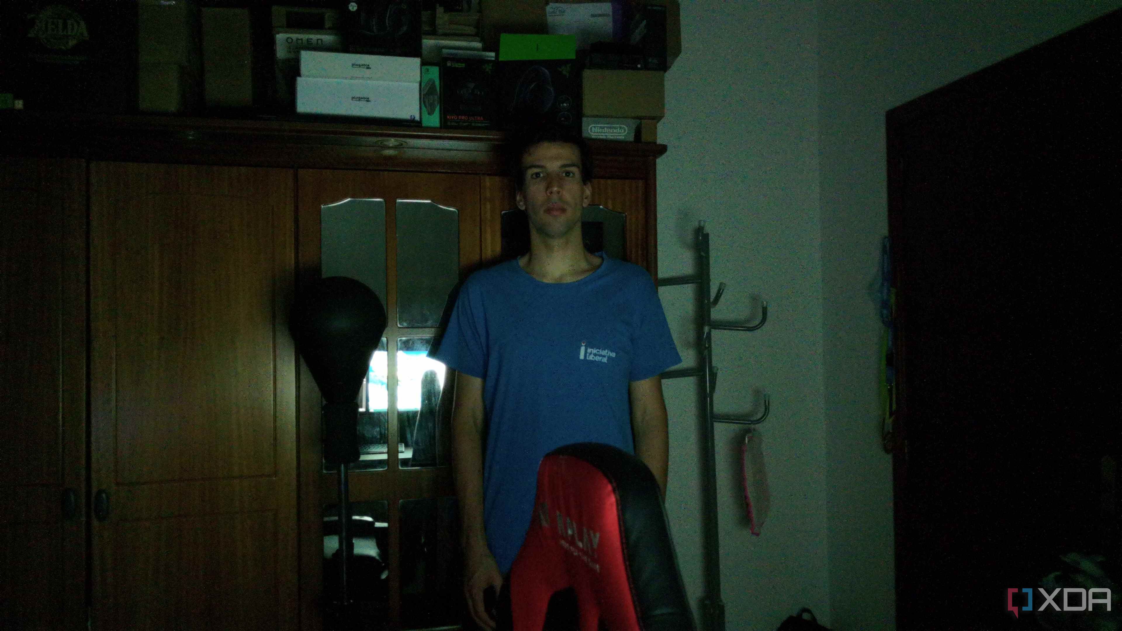 A man standing in a dark room in front of a wardrobe. The webcam has managed to track the user and keep him centered in the frame