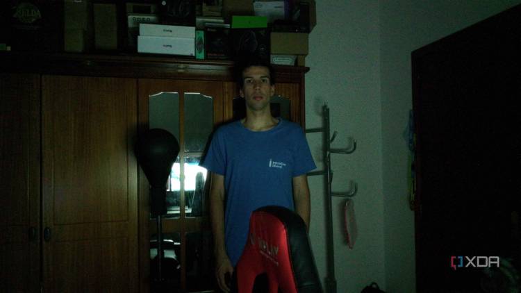 A man standing in a dark room in front of a wardrobe. The webcam has managed to track the user and keep him centered in the frame