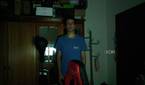 A man standing in a dark room in front of a wardrobe. The webcam has managed to track the user and keep him centered in the frame