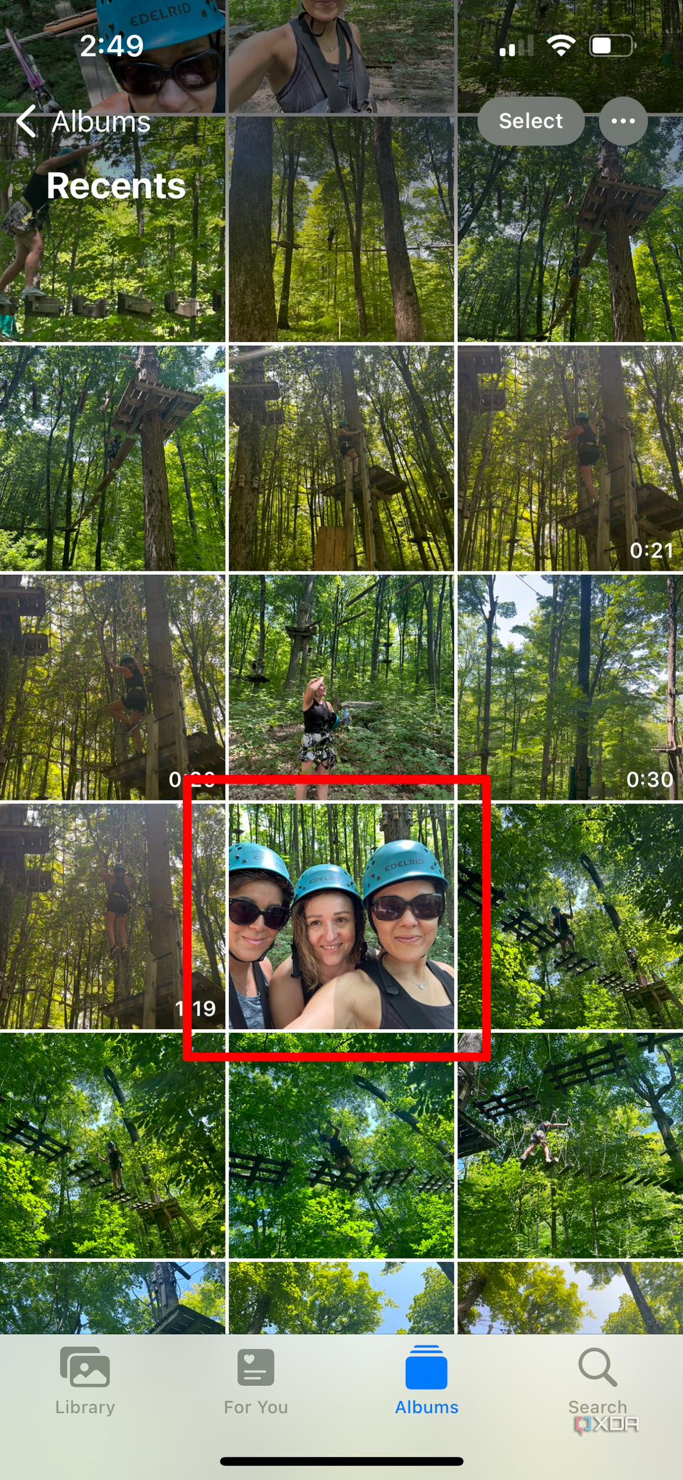 A photo library page on an iPhone with an image of three women wearing headgear selected.