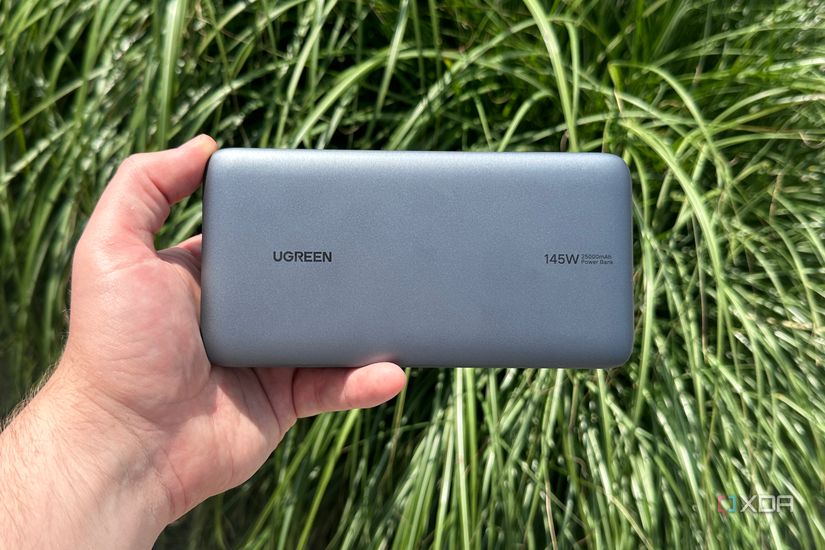 UGreen's Power Bank in hand in front of a bush. 