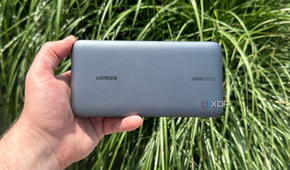 UGreen's Power Bank in hand in front of a bush.