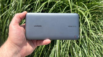 UGreen's Power Bank in hand in front of a bush.