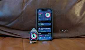 The Apple Fitness app on an iPhone 14 and Apple Watch propped up side by side.