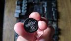 An image of a CMOS battery with the MSI B450 A-Pro motherboard in the background