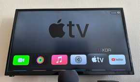 Apple TV 4K 3 next to HomePod Mini on a table with Apple TV displayed on the screen