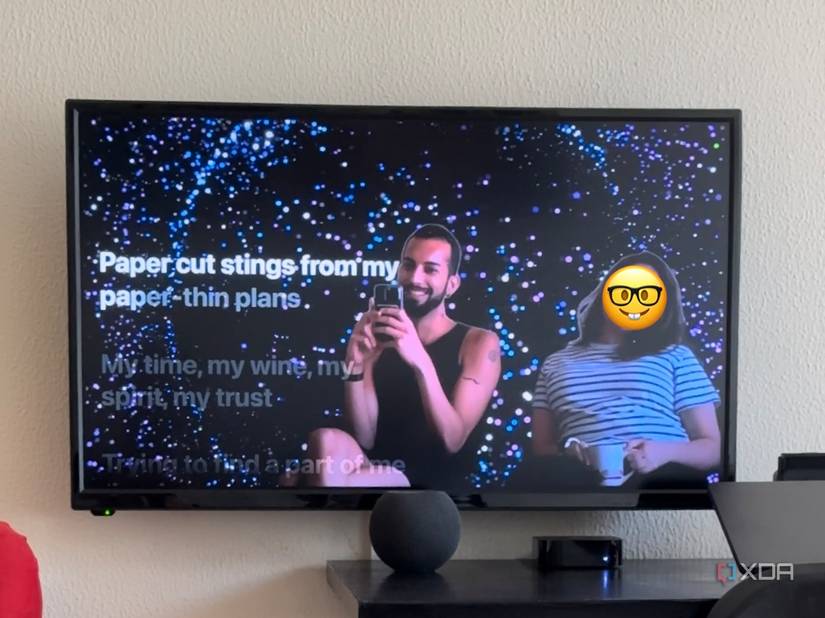Mahmoud Itani and another person appearing on the TV screen next to Apple Music lyrics with special effects applied