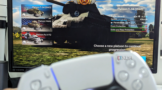 An image showing a PS5 DualSense controller with a monitor in the background running War Thunder Mobile game on DeX.