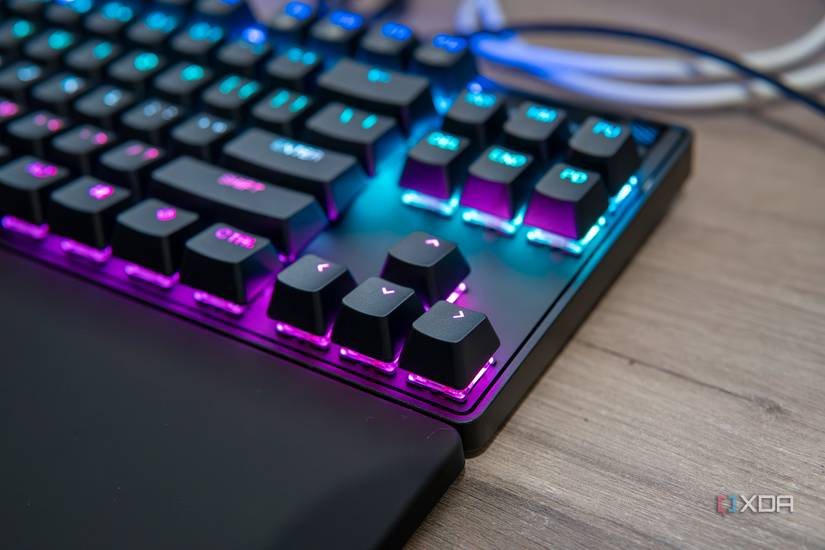 Close-up view of the arrow keys on a SteelSeries Apex Pro TKL keyboard with RGB lighting enables in pink and blue