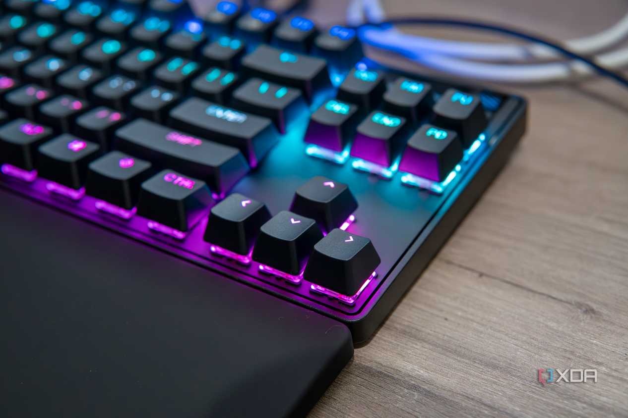 Close-up view of the arrow keys on a SteelSeries Apex Pro TKL keyboard with RGB lighting enables in pink and blue