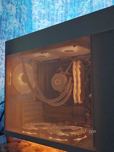 An image showing a white PC case with RGB-enabled components inside that can be seen through the mesh pattern.