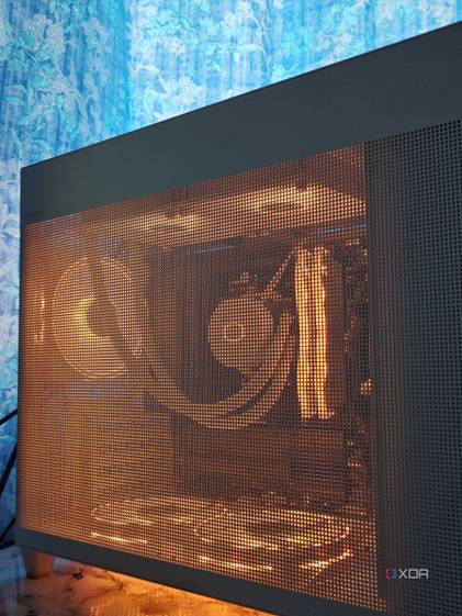An image showing a white PC case with RGB-enabled components inside that can be seen through the mesh pattern.
