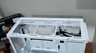 An image showing the top panel of a white-colored Asus Prime AP201 case.