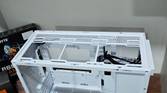 An image showing the top panel of a white-colored Asus Prime AP201 case.