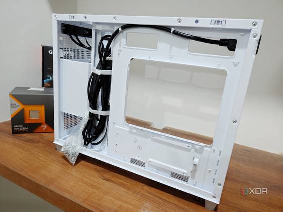 An image showing the motherboard side panel of a white-colored Asus Prime AP201 case.