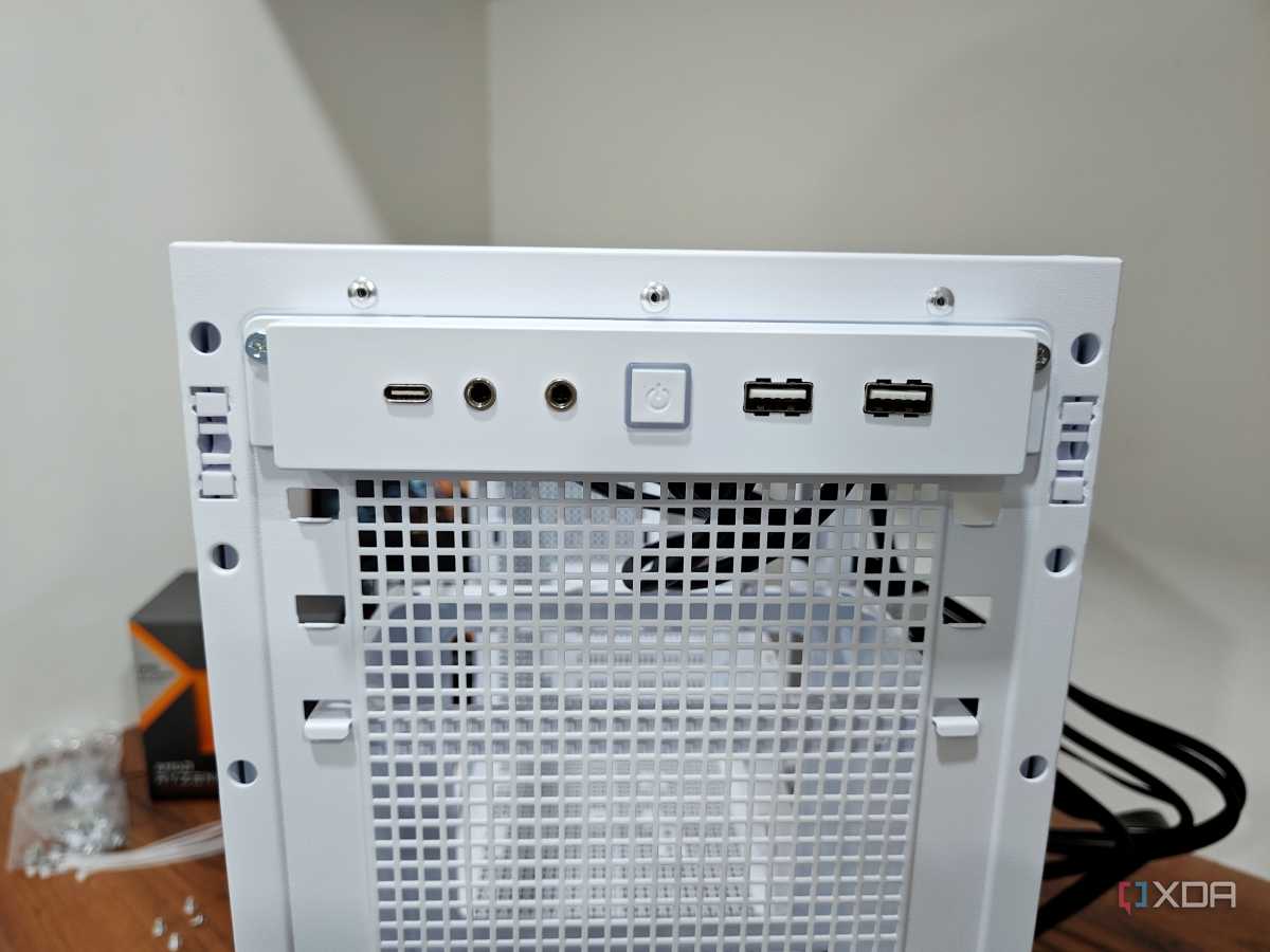 An image showing the front I/O panel of a white-colored Asus Prime AP201 case.