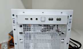 An image showing the front I/O panel of a white-colored Asus Prime AP201 case.