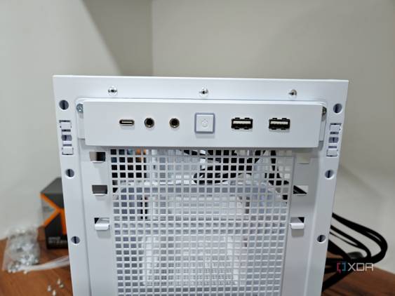 An image showing the front I/O panel of a white-colored Asus Prime AP201 case.