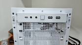 An image showing the front I/O panel of a white-colored Asus Prime AP201 case.