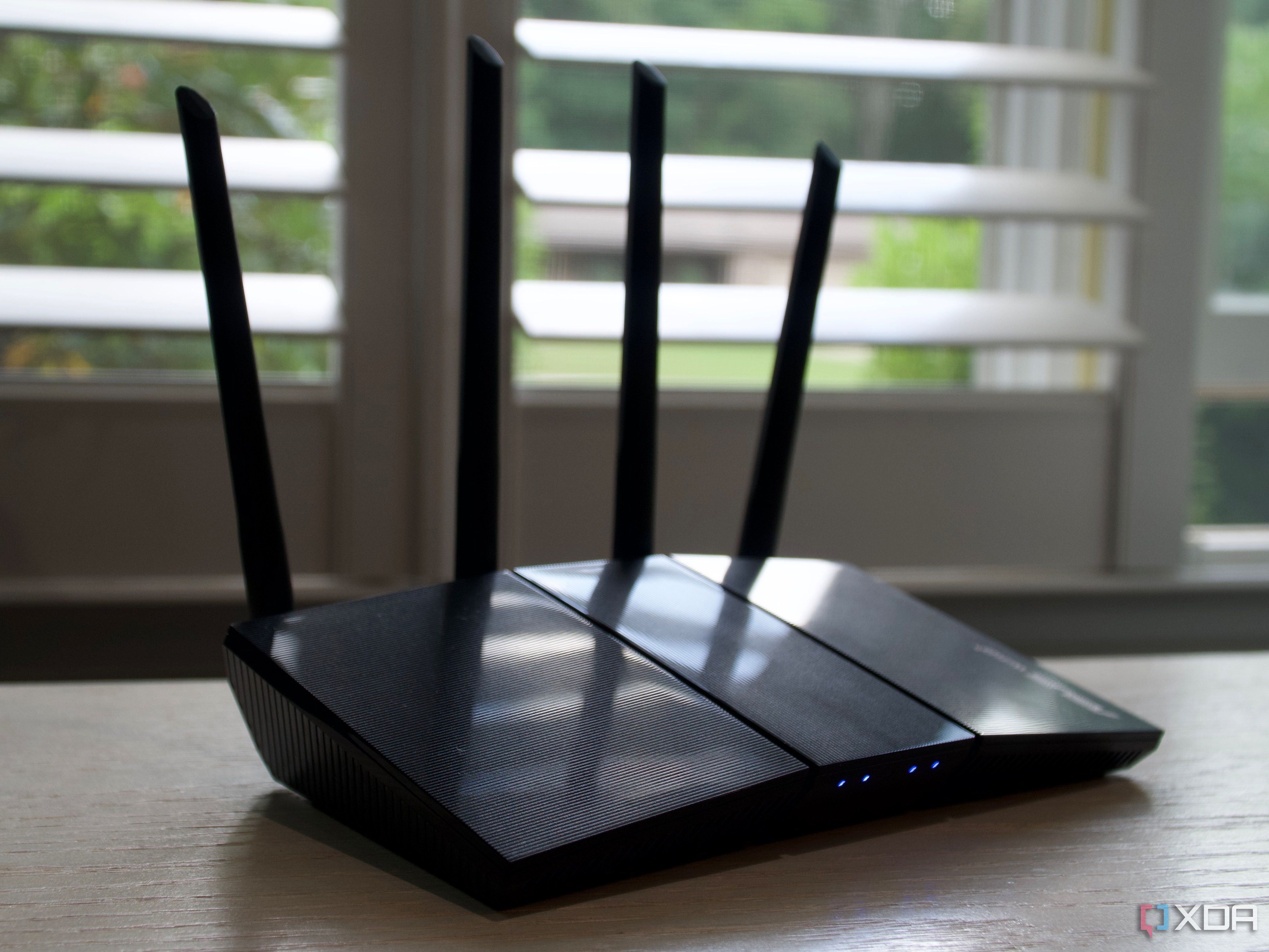 Asus RT-AX57 in front of a window with light reflections