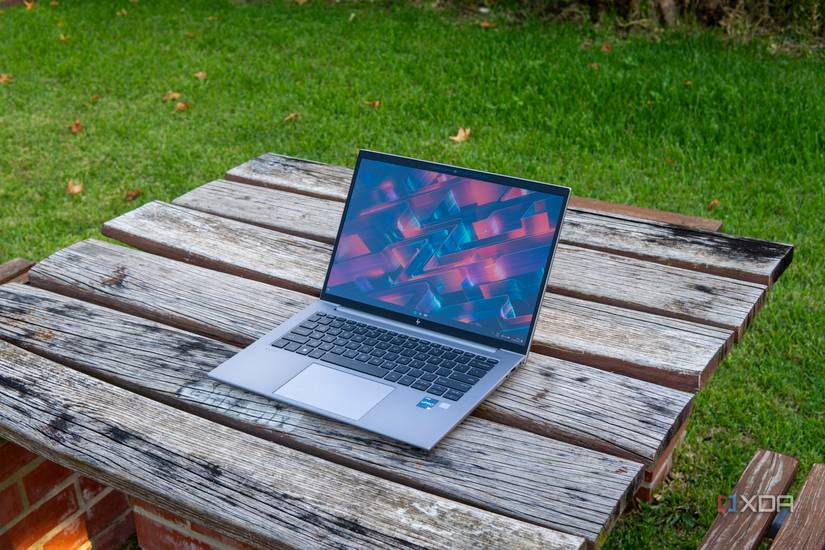 HP ZBook Firefly 14 G10 laptop on a wooden table in a garden.