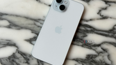 The back of an iPhone 15 on a marble tabletop.