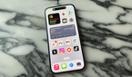 The iPhone 15's display on a marble tabletop.