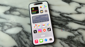 The iPhone 15's display on a marble tabletop.