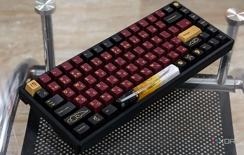 An image showing a Keychron K2V2 keyboard with GMK Red Samurai keycaps kept on a glass table.
