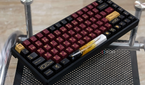 An image showing a Keychron K2V2 keyboard with GMK Red Samurai keycaps kept on a glass table.