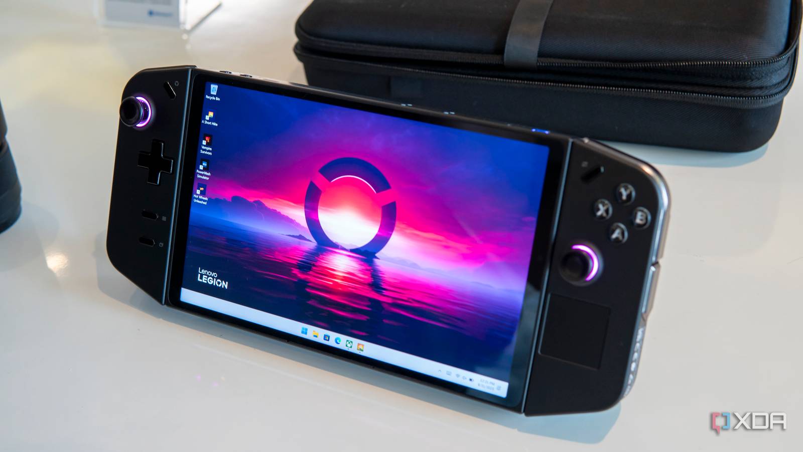 Angled front view of the Lenovo Legion Go handheld with showing a desktop background with pink and blue colors