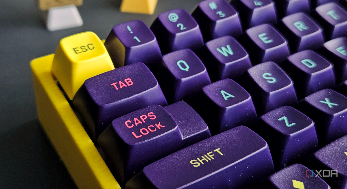 An image of a mechanical keyboard with a yellow case and purple MT3 keycaps.