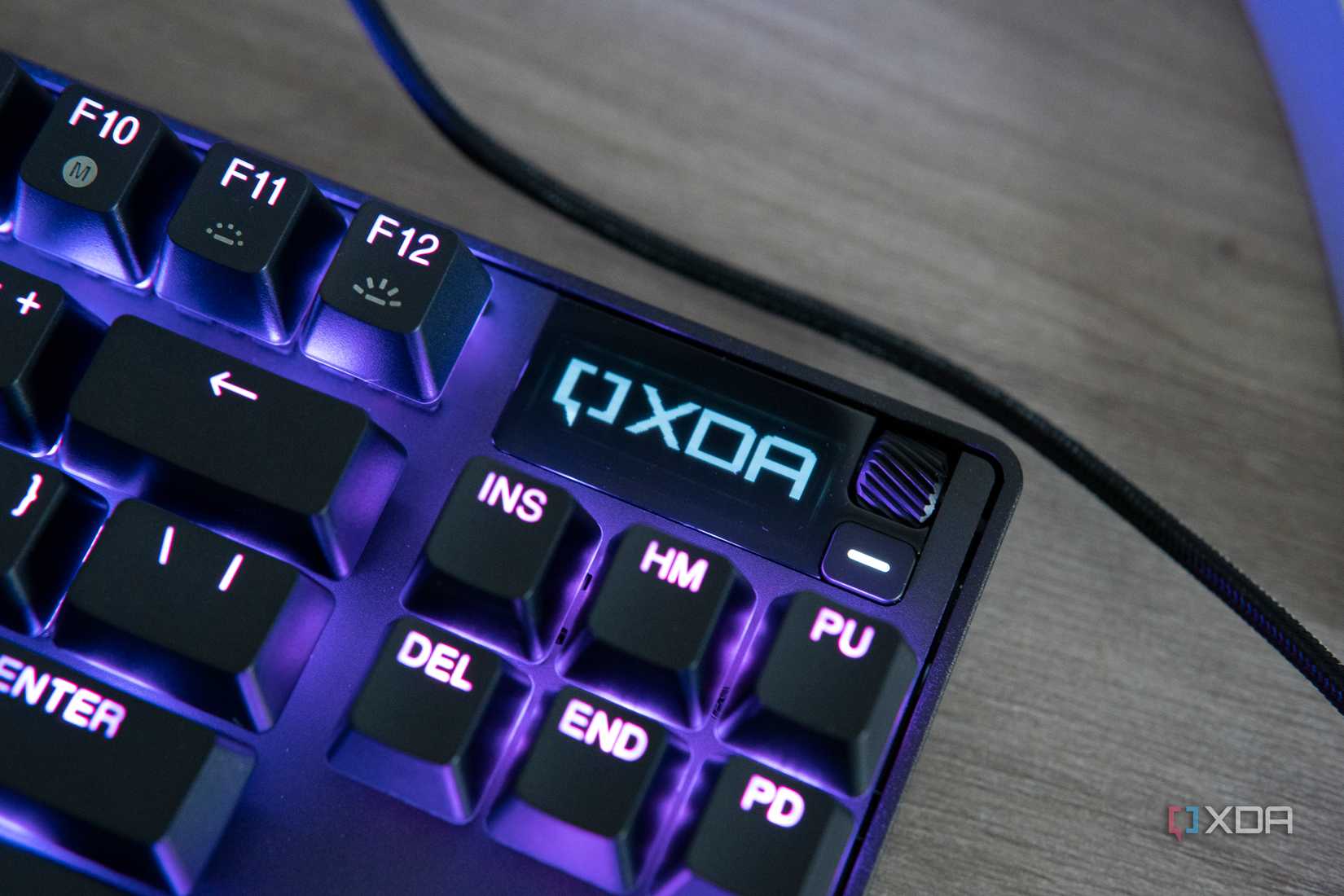 Close-up view of the OLED screen on the SteelSeries Apex Pro TKL displaying the XDA logo