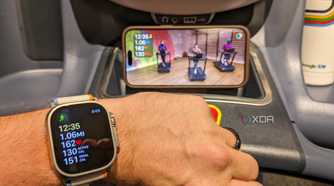 Apple Watch with treadmill workout on display in background