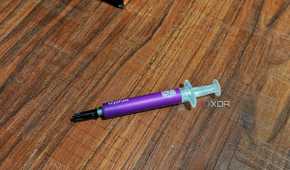 An image showing a tube of Cooler Master CryoFuze thermal paste kept on a wooden surface.