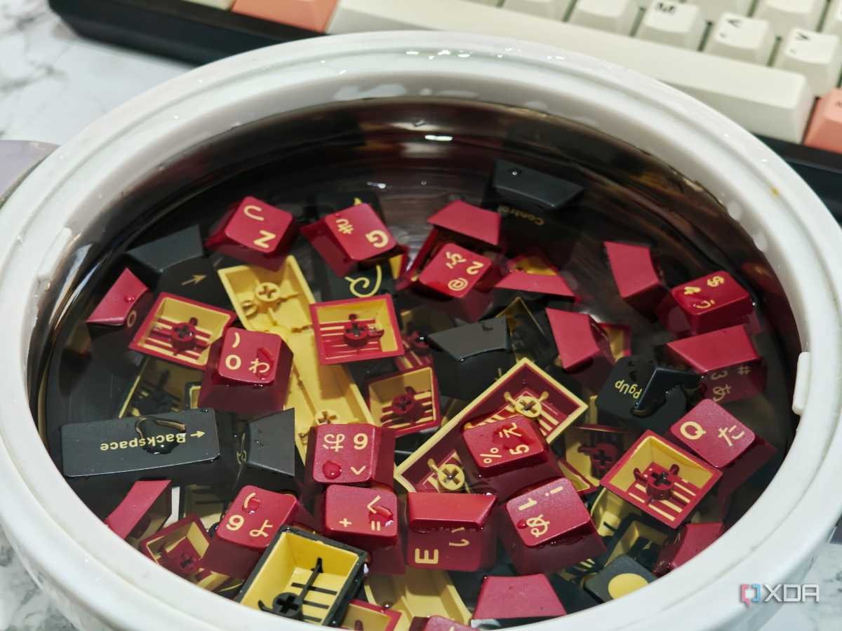 An image showing GMK Red Samurai keycaps soaking in a bowl of lukewarm water.