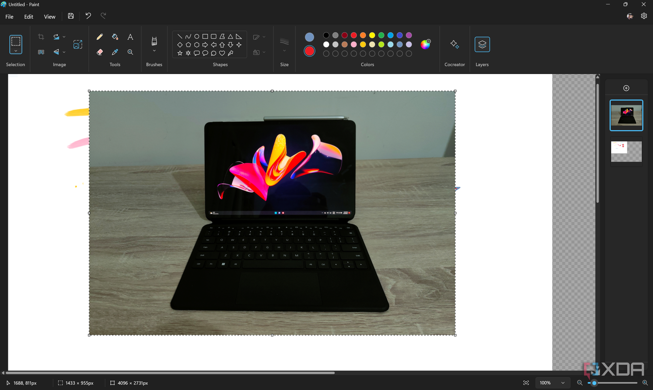 Screenshot of the Paint app in Windows 11 with a layer with a photo of a tablet open on a second layer