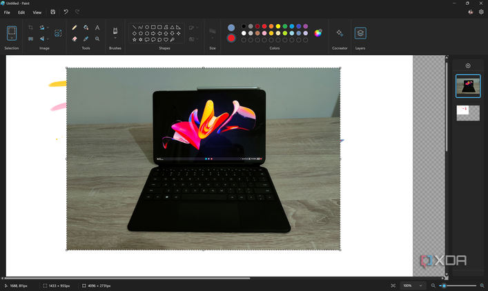 Screenshot of the Paint app in Windows 11 with a layer with a photo of a tablet open on a second layer