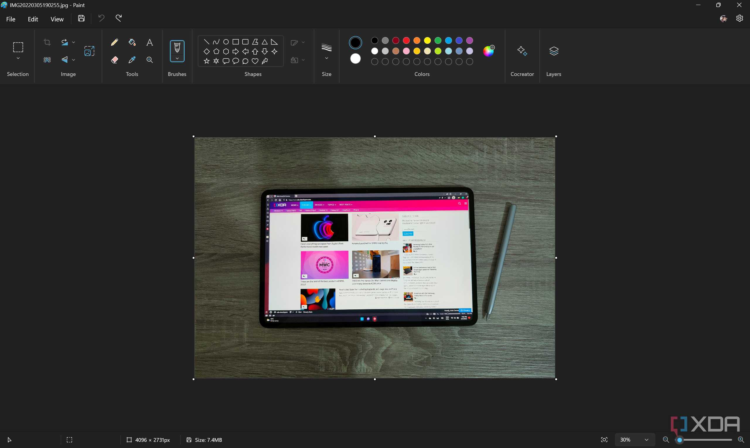 Screenshot of Paint with a picture of a tablet on top of a wooden surface