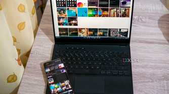 A laptop running intel Unison next to the phone linked to the app. The same photos that are on the phone are visible on the laptop