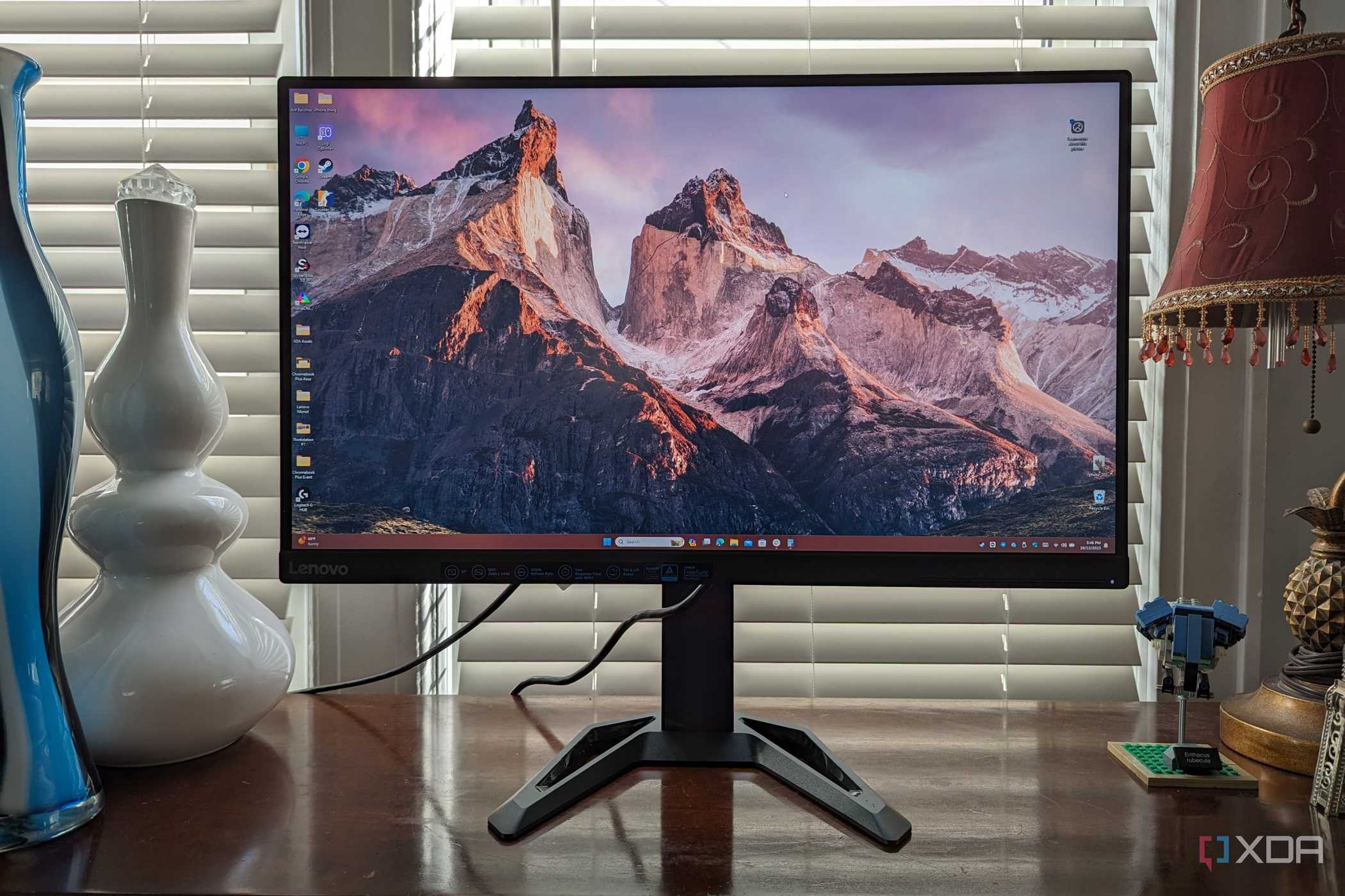Lenovo G27q-30 monitor sitting on a desk with a vase and other items in view