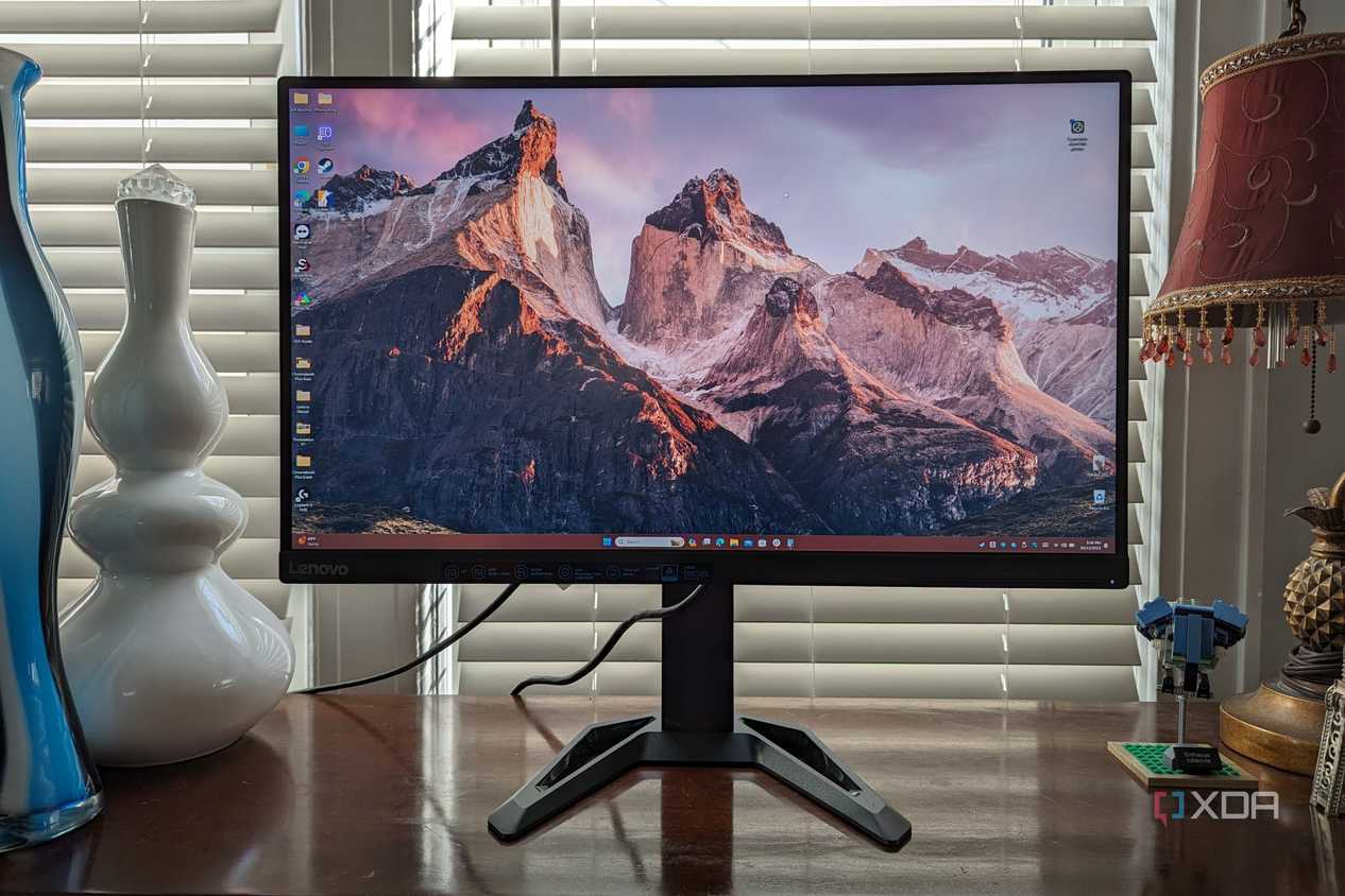 Lenovo G27q-30 monitor sitting on a desk with a vase and other items in view