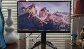 Lenovo G27q-30 monitor sitting on a desk with a vase and other items in view
