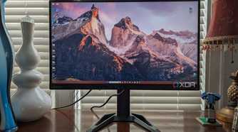 Lenovo G27q-30 monitor sitting on a desk with a vase and other items in view